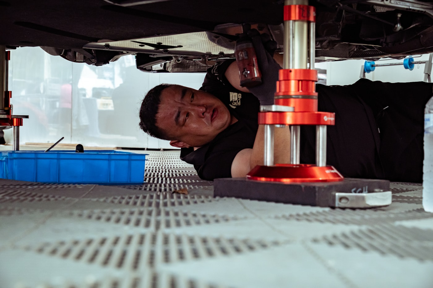 車の下で整備をするスタッフ
